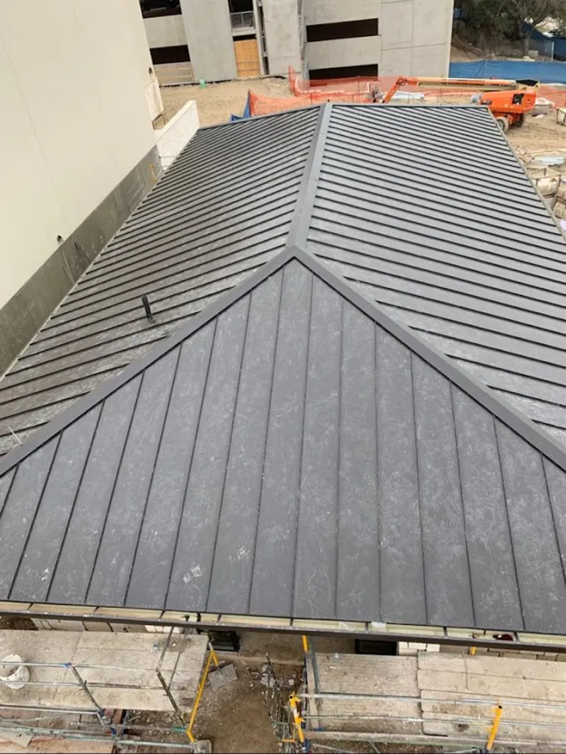 Commercial metal roof construction with crane equipment in Waukegan